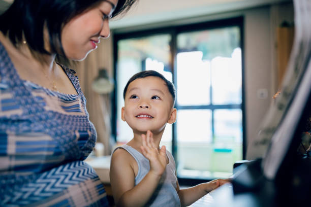 istock Chinese mother teaching her son how to play piano. 1168891718