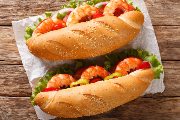istock Fresh Sandwich with king prawns, vegetables close-up on parchment. Horizontal top view 1168891725