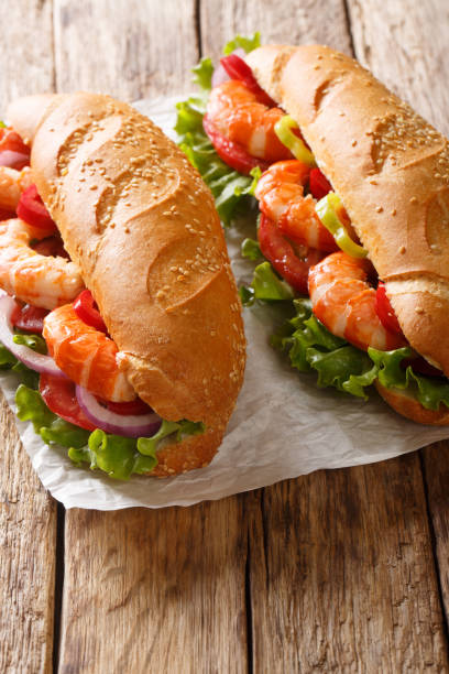 istock Fresh Sandwich with king prawns, vegetables close-up on parchment. Vertical 1168891875