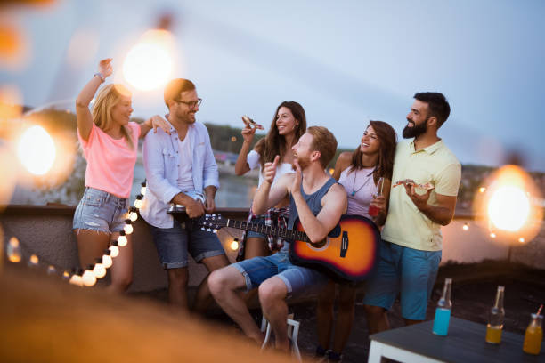 istock Group of happy friends having party on rooftop 1168892647
