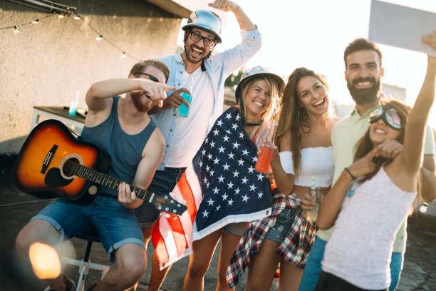 istock Young friends having fun at a rooftop party, playing the guitar, singing, dancing and drinking 1168892753