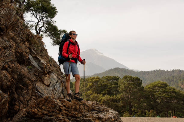 istock Girl standing on the rock with hiking backpack 1168892990