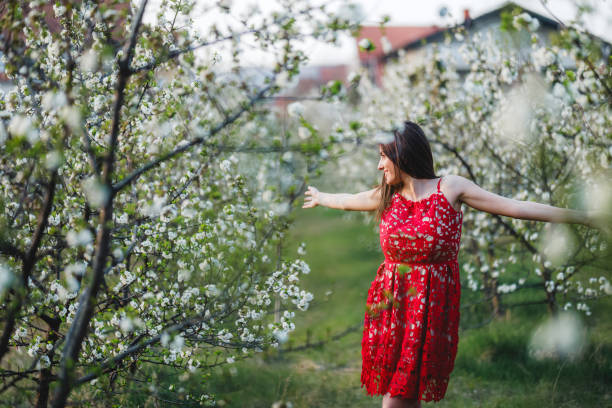 istock Young woman among blooming trees 1168893627