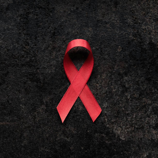 спид осведомленности красная лента на темном фоне - aids awareness ribbon фотографии стоковые фото и изображения