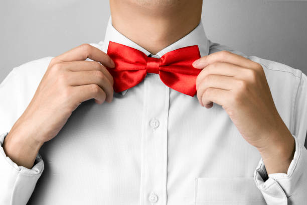 istock Man ties a red bowtie at the collar 1168895834