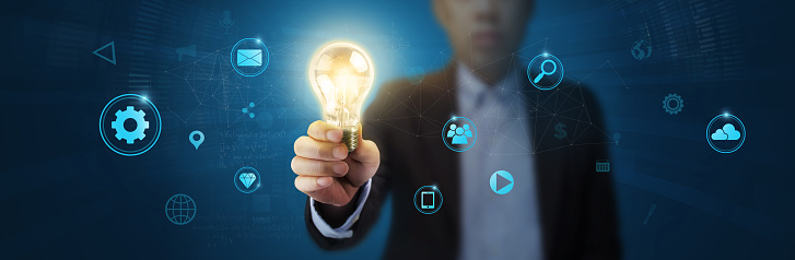 Businessman holding light bulb and new ideas of business with innovative technology network connection. Business innovation concept.