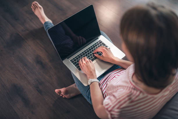 istock Woman surfs the web on a laptop at home 1168896736
