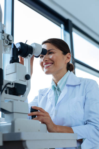 istock Cheerful female doctor looking into the microscope 1168896878