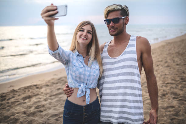 istock Beautiful cheerful couple taking selfie at the beach 1168897224