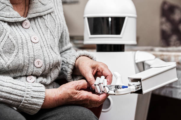 robot cuidador autónomo está sosteniendo una jeringa de insulina, dándosela a una mujer adulta de edad en su sala de estar, concepto de vida asistida ambiente - robot fotografías e imágenes de stock