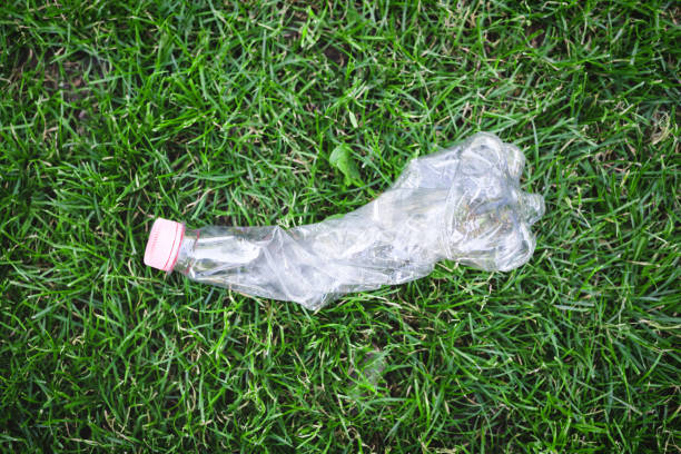 plastic bottle on green grass. - toxic substance spilling pouring bottle imagens e fotografias de stock