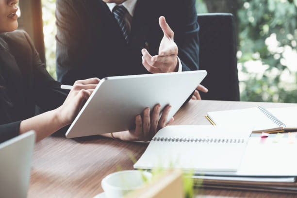 femme d'affaires et avocats discutant et utilisant la tablette numérique sur le bureau en bois dans le bureau. droit, services juridiques, conseils, concept de justice. - guidance photos et images de collection