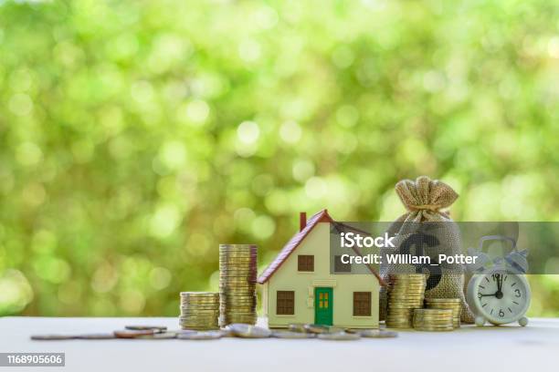 Residential Real Estate Loan Financial Concept House Model Coins Us Dollar Bag White Clock On A Table Depicts Home Loan Or Borrowing Money To Buy Purchase A New Home For First Time Homebuyer Stock Photo - Download Image Now