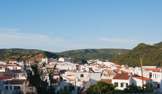 White houses of the Ferreries village with green hills around in Menorca one of the Spanish island