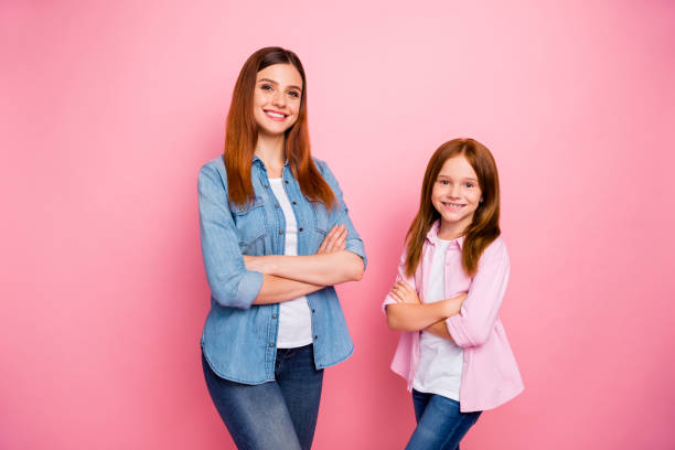 portrait of friendly ladies crossing their hands with toothy smile isolated over pink background - offspring child toothy smile beautiful imagens e fotografias de stock