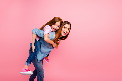 Funny attractive little lady and her, mom spending weekend together wear casual clothes isolated pink background