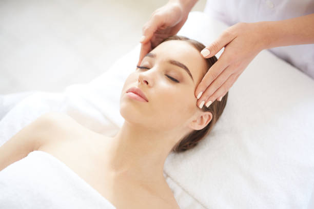 hermosa mujer disfrutando del masaje de la cabeza en spa - head massage massaging facial massage beautician fotografías e imágenes de stock