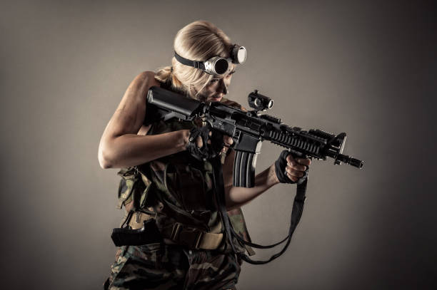 istock attractive blond woman with gun in hands 1168910881