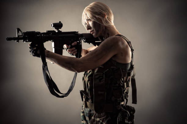 istock young blond woman with gun 1168910922