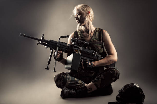 istock attractive blond woman with machine gun in hands 1168911604