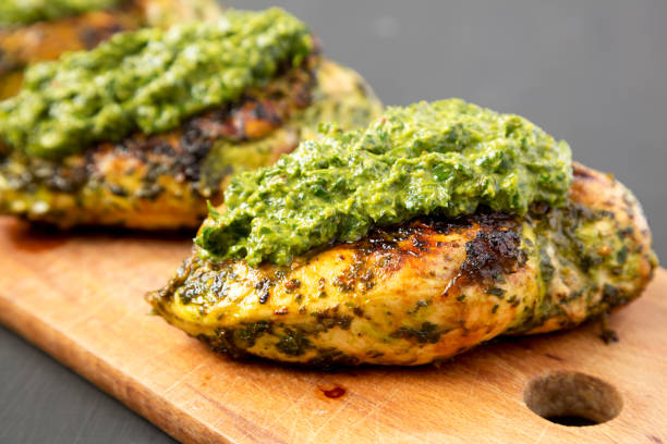 istock Grilled chimichurri chicken breast on a rustic wooden board on a black surface, side view. Close-up. 1168915832