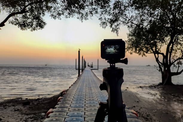 istock Camera mounted on a tripod photograph the pier and sunrise 1168916299