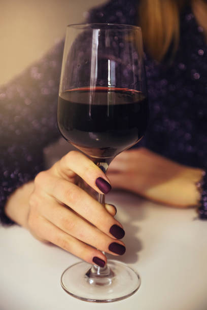 Zhenschina is holding a glass of wine. Soft focus. Toning. Vertical shot. Celebration. The lights of a sun. - Image