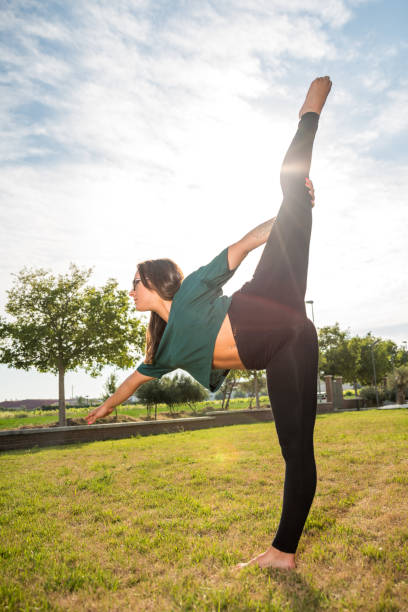 istock Young woman stretching legs in the grass 1168922387