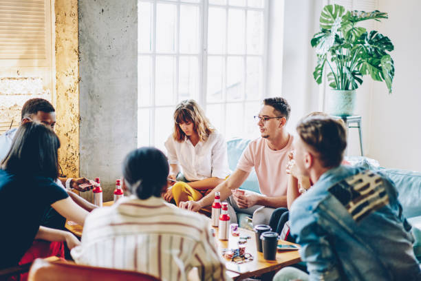 istock Group of multicultural young people dressed in casual wear playing in board game during friendly meeting in apartment.Diverse hipsters spending leisure time together on poker game in flat 1168924196