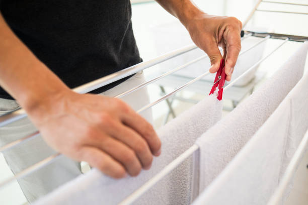 man hanging clothes on a drying rack - 2333 imagens e fotografias de stock