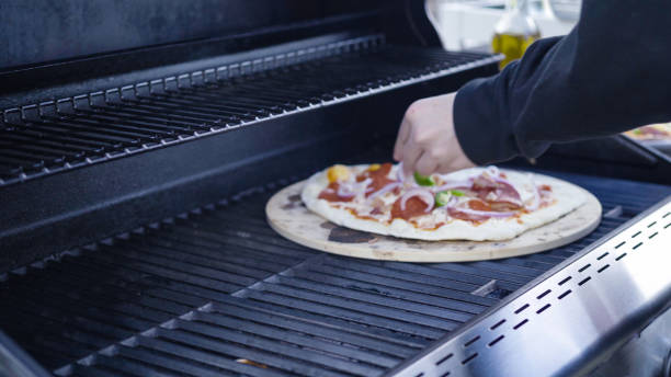 istock Cooking pizza on outdoor gas grill. 1168927853