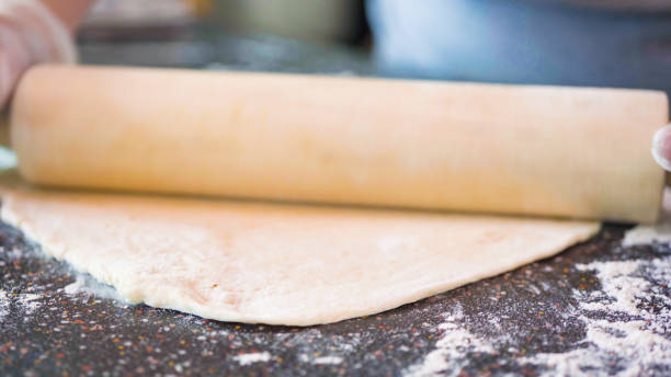 istock Rolling out pizza dough for individual small pizzas. 1168928073