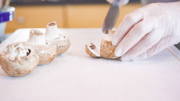 istock Slicing baby bella mushrooms on a white cutting board. 1168928430