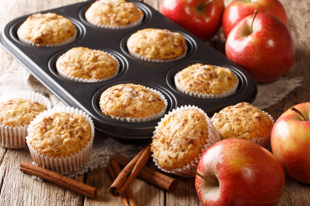 Sweet dessert apple muffins with cinnamon close-up in a baking dish. horizontal Sweet dessert apple muffins with cinnamon close-up in a baking dish on the table. horizontal muffin stock pictures, royalty-free photos & images
