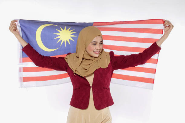 istock Young Woman Holding Malaysian Flag Against White Background 1168929536