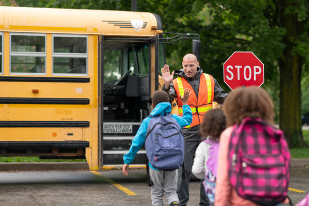 istock Smiling crossing guard helps students safely get on school bus 1168934166