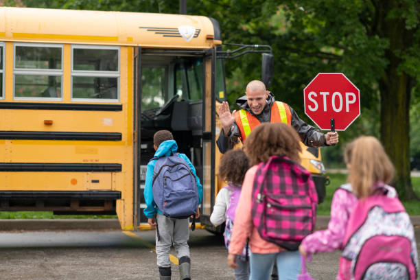 istock Smiling crossing guard helps students safely get on school bus 1168934168
