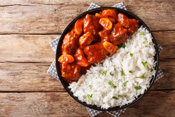 istock Spicy beef cooked with apples in tomato sauce with rice side dish close-up on a plate. Horizontal top view 1168934369