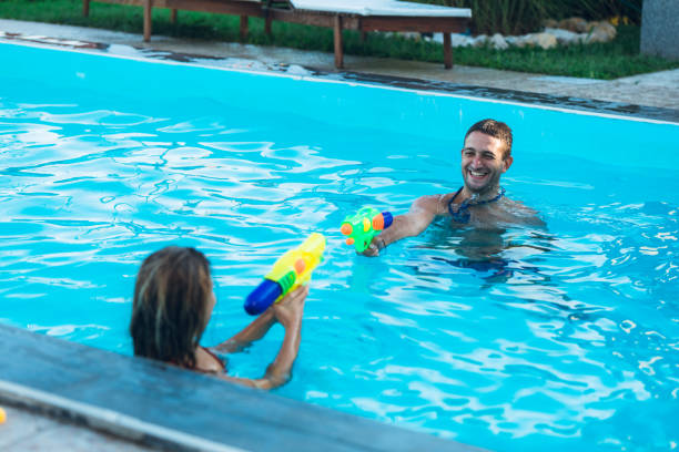 istock Couple water fight in pool 1168935901