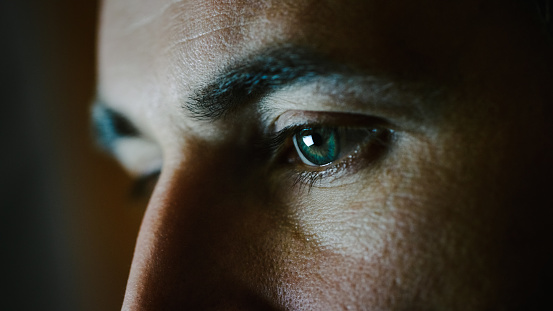 Close-up of a Green-Blue Man's Eyes with Screen Reflecting in Them.