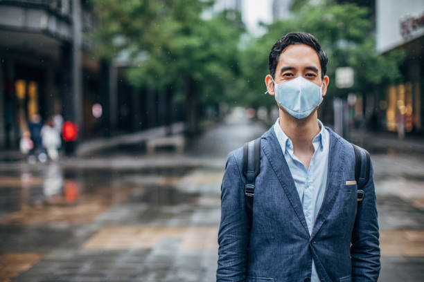 istock Young gentleman with pollution mask on the street 1168939652