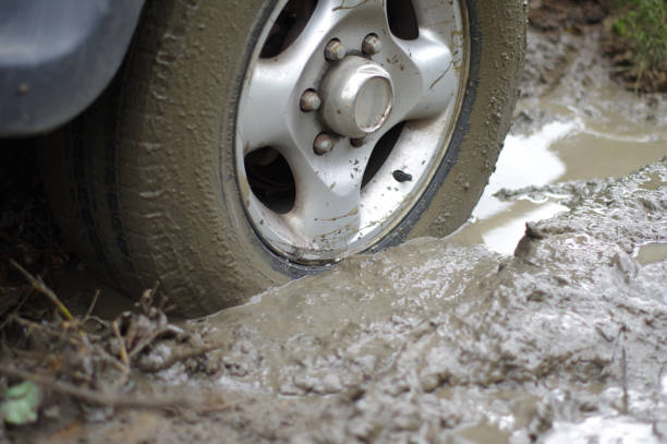 istock Car stuck, car wheel in a dirty puddle, rough terrain 1168940320