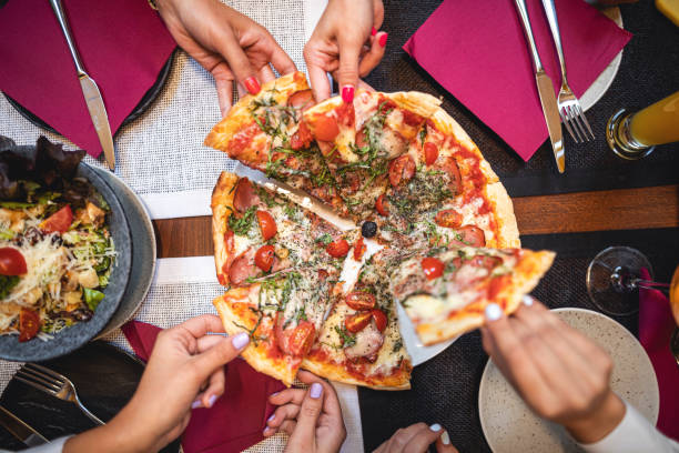 istock Women eating pizza at a restaurant 1168942087