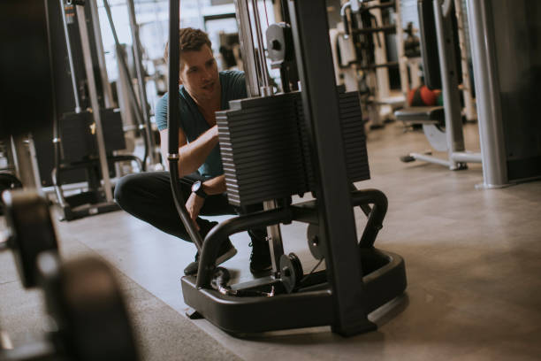 istock Athlete adding weight plates, preparing for his weightlifting workout at gym 1168942994