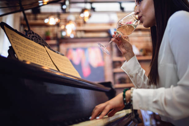 istock Female musician drinking white wine while playing a piano 1168943019