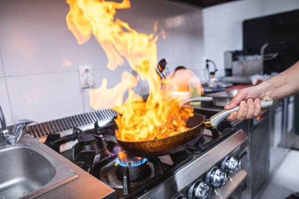 wykwalifikowany kucharz gotuje z płonącym ogniem w kuchni restauracyjnej - pan frying pan fire fried zdjęcia i obrazy z banku zdjęć