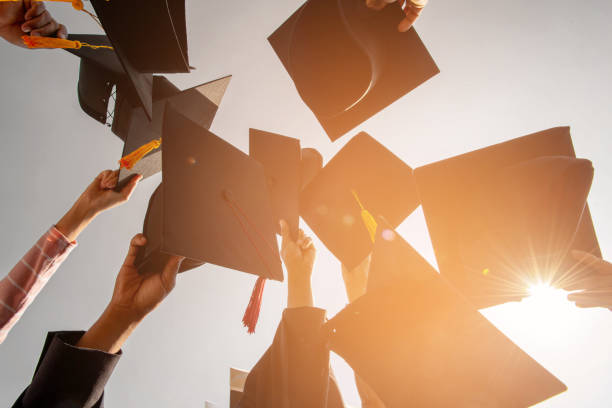 istock Black hat of the graduates floating in the sky. 1168945081