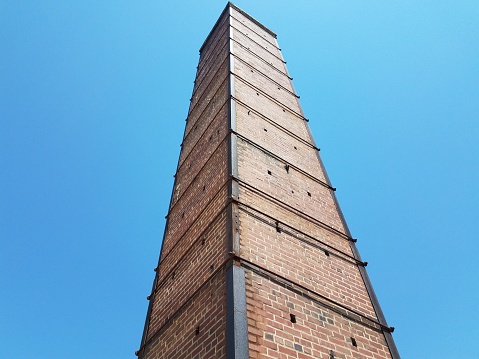 tall red brick chimney or masonry with metal support rods