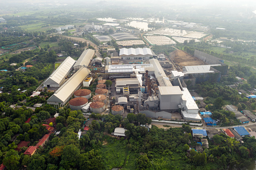 Aerial view, Processing factory of molasses and sugar with emission smoke from chimneys at countryside