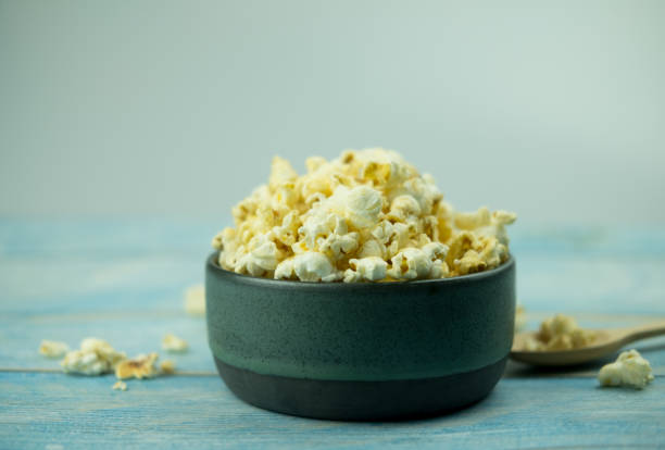 istock Popcorn in a bowl against blue wooden background 1168950622